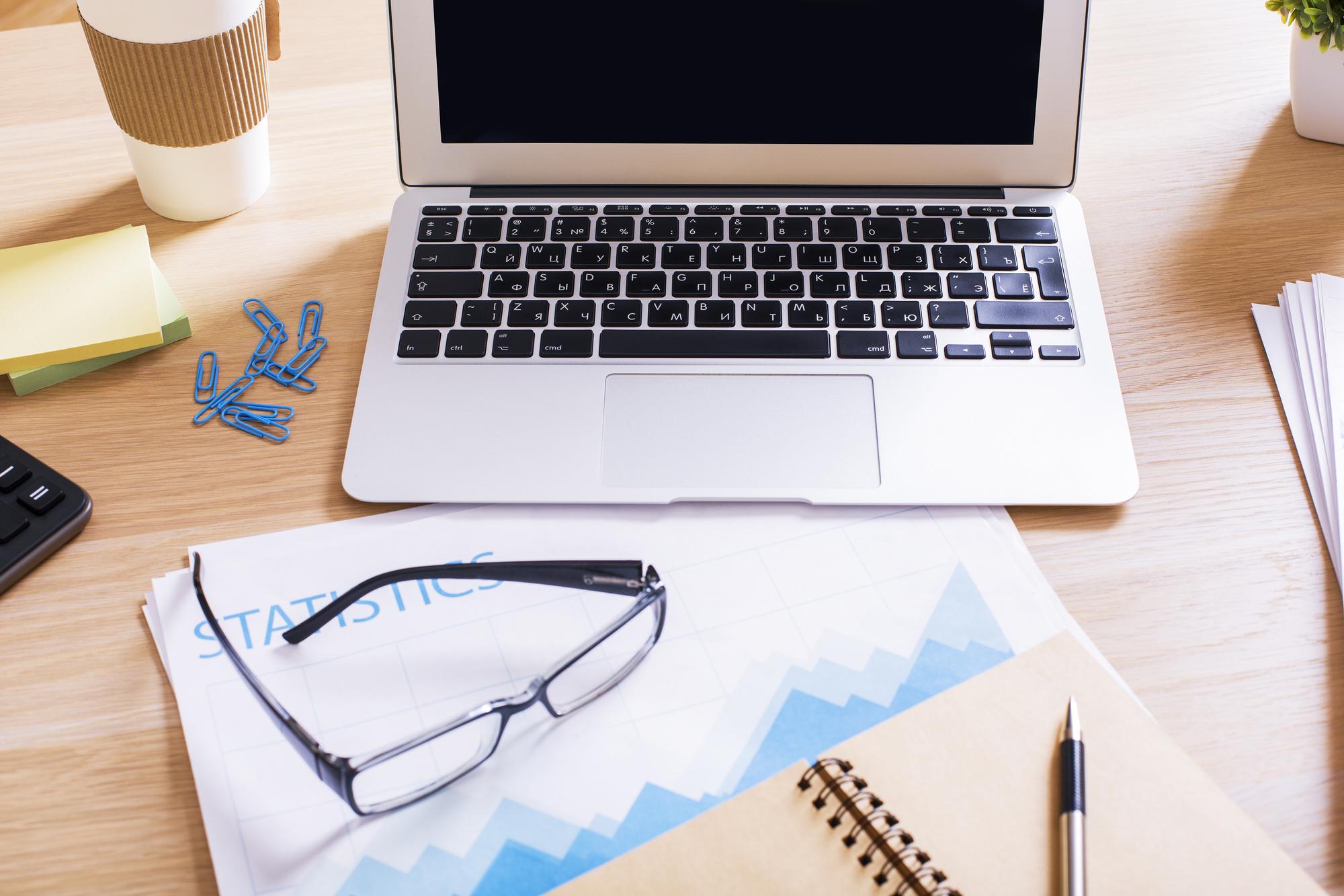 Workspace with financial reports and laptop